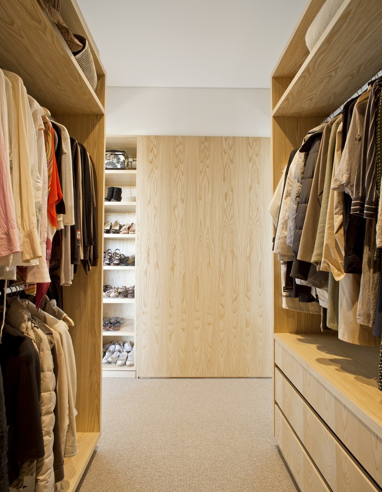 Large contemporary gender-neutral walk-in wardrobe in Sydney with flat-panel cabinets, light wood cabinets and carpet.
