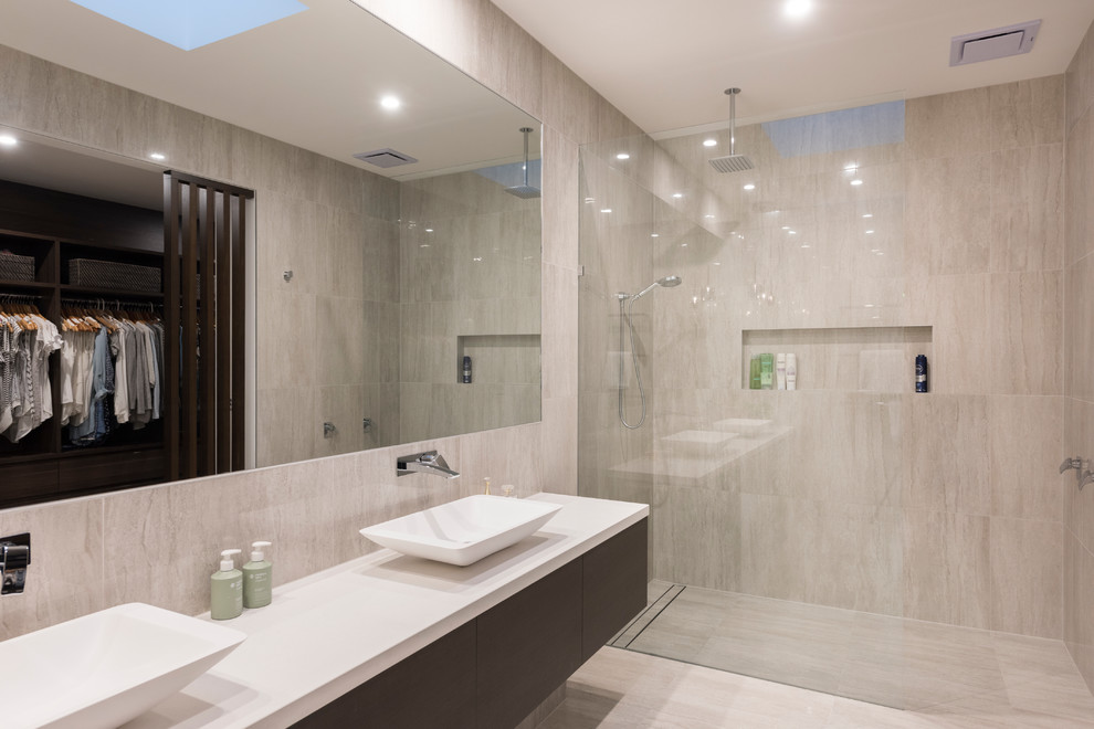 Design ideas for a contemporary master bathroom in Melbourne with furniture-like cabinets, dark wood cabinets, an open shower, a wall-mount toilet, gray tile, porcelain tile, grey walls, porcelain floors, a vessel sink, engineered quartz benchtops, grey floor, an open shower and black benchtops.