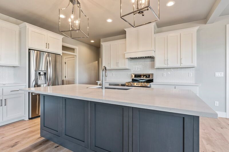 Example of a transitional l-shaped light wood floor eat-in kitchen design with an undermount sink, shaker cabinets, gray cabinets, quartz countertops, white backsplash, mosaic tile backsplash, stainless steel appliances, an island and white countertops