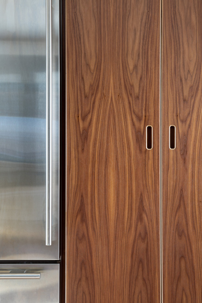 Modelo de cocina retro con puertas de armario de madera en tonos medios, despensa y armarios con paneles lisos