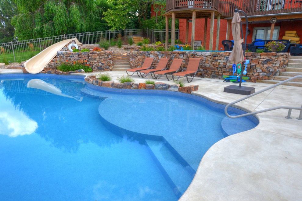 Design ideas for a large traditional backyard kidney-shaped lap pool in Philadelphia with a water slide and concrete slab.