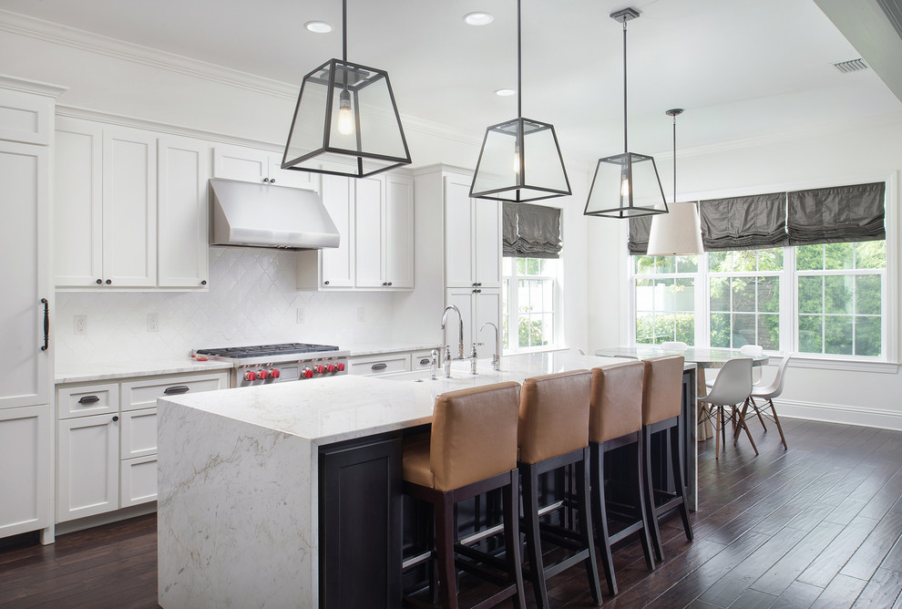 Photo of a large transitional galley eat-in kitchen in Tampa with white cabinets, marble benchtops, white splashback, dark hardwood floors, with island, a farmhouse sink, shaker cabinets and stainless steel appliances.