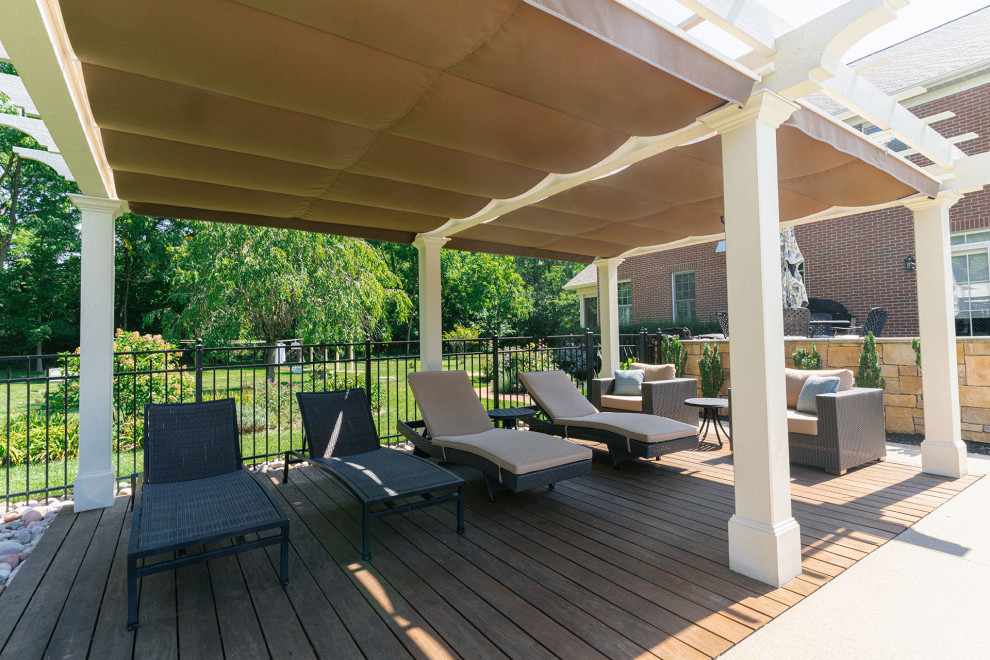 Traditional backyard and ground level deck in Columbus with with privacy feature, a pergola and metal railing.