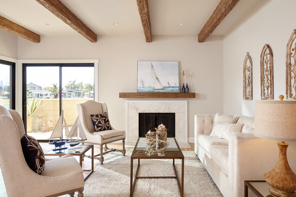 This is an example of a mid-sized beach style open concept living room in San Francisco with a standard fireplace, grey walls, light hardwood floors, a tile fireplace surround and beige floor.