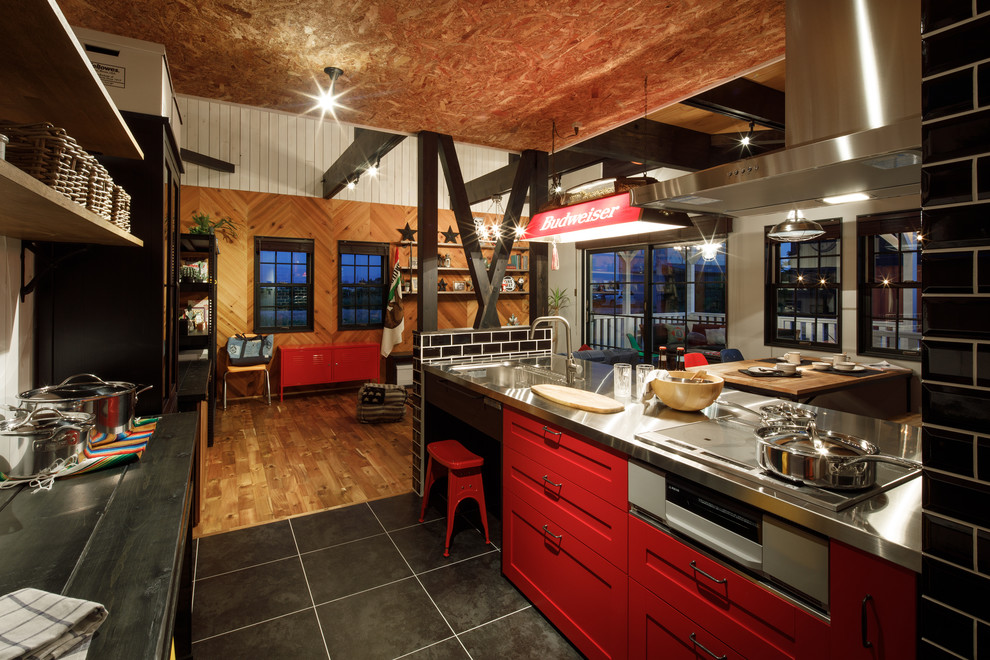 Design ideas for a beach style single-wall open plan kitchen in Other with a single-bowl sink, recessed-panel cabinets, red cabinets, stainless steel benchtops, a peninsula, black floor and black benchtop.