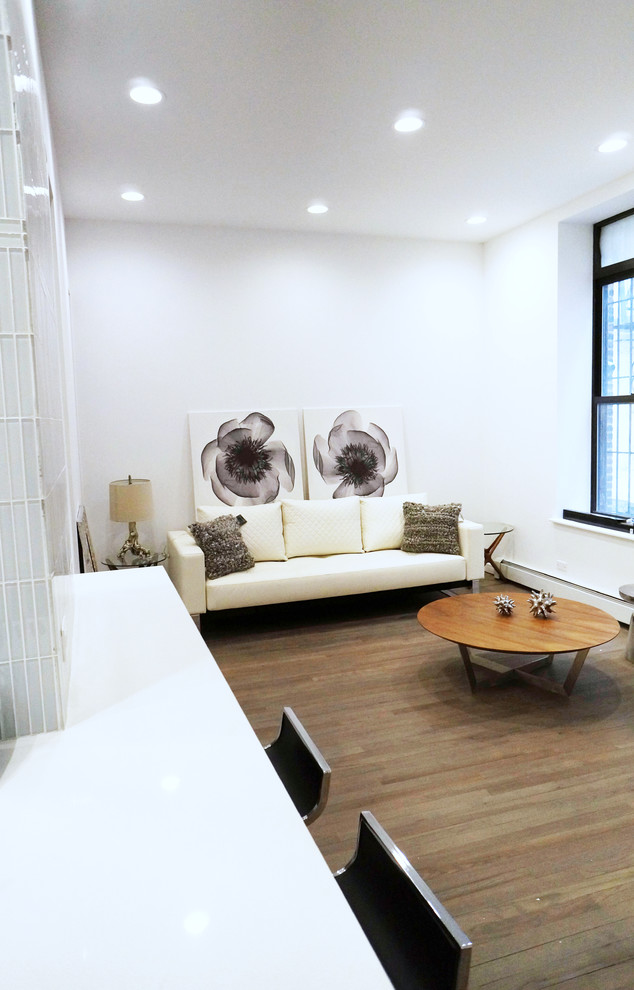 This is an example of a small contemporary living room in New York with medium hardwood floors and brown floor.