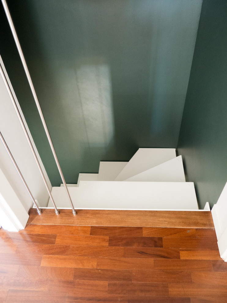 Exemple d'un petit escalier peint éclectique en U avec des marches en bois peint et un garde-corps en câble.