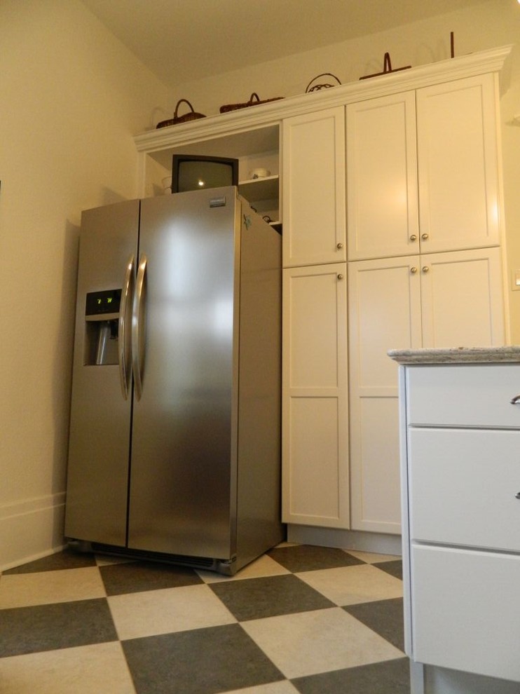 Inspiration for a transitional enclosed kitchen remodel in Toronto with an undermount sink, recessed-panel cabinets, quartz countertops, white backsplash, ceramic backsplash, stainless steel appliances and an island