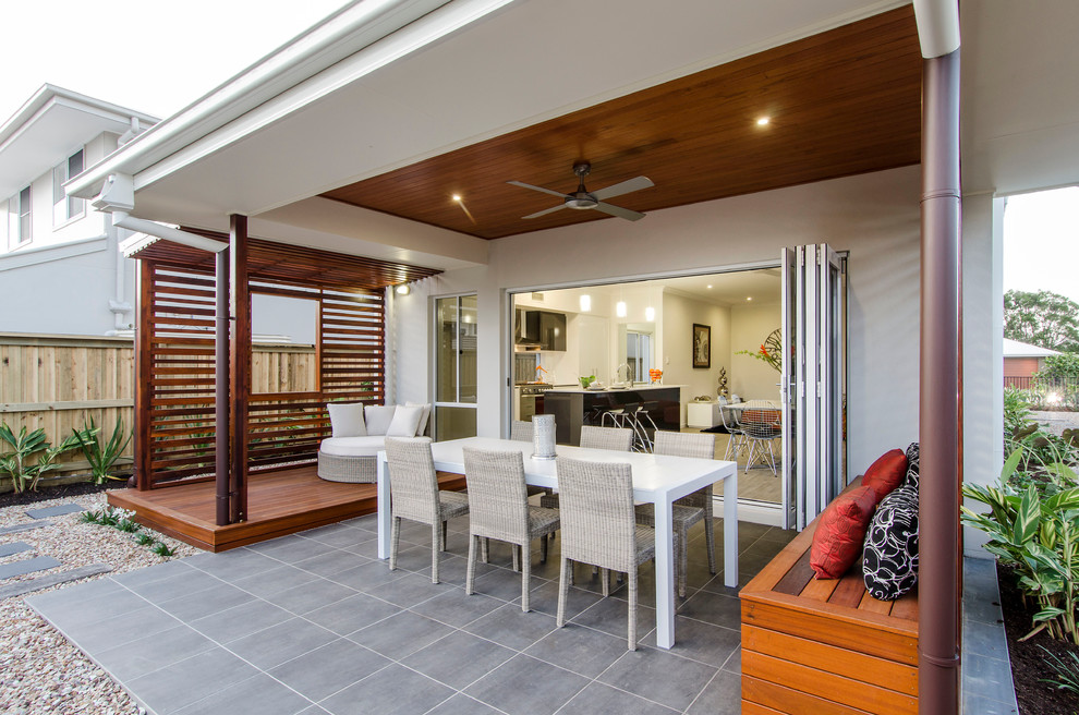 Photo of a contemporary backyard patio in Brisbane with tile and a roof extension.