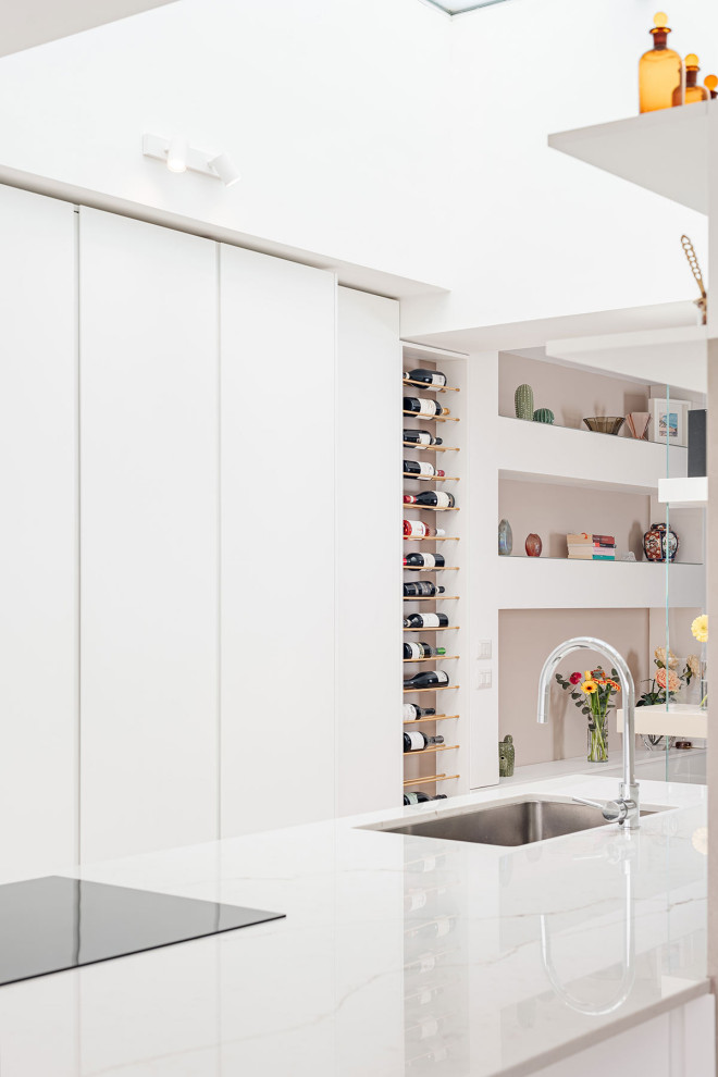 Idéer för att renovera ett funkis vit vitt kök, med en enkel diskho, luckor med profilerade fronter, vita skåp, bänkskiva i kvarts, svarta vitvaror, klinkergolv i porslin, en köksö och beiget golv