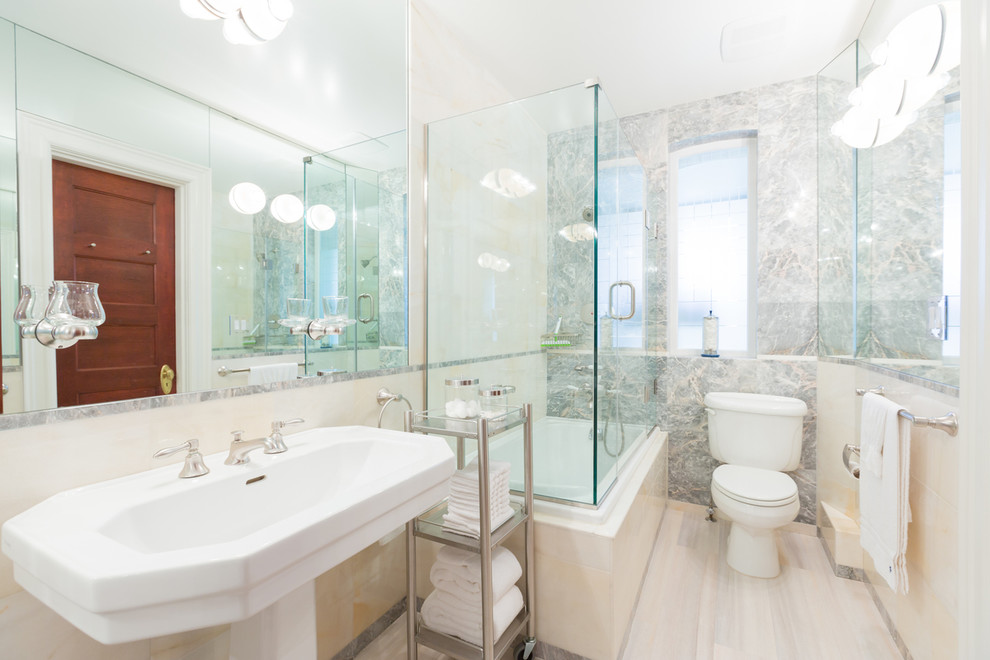 This is an example of a traditional bathroom in DC Metro with a pedestal sink, a drop-in tub, a shower/bathtub combo and light hardwood floors.