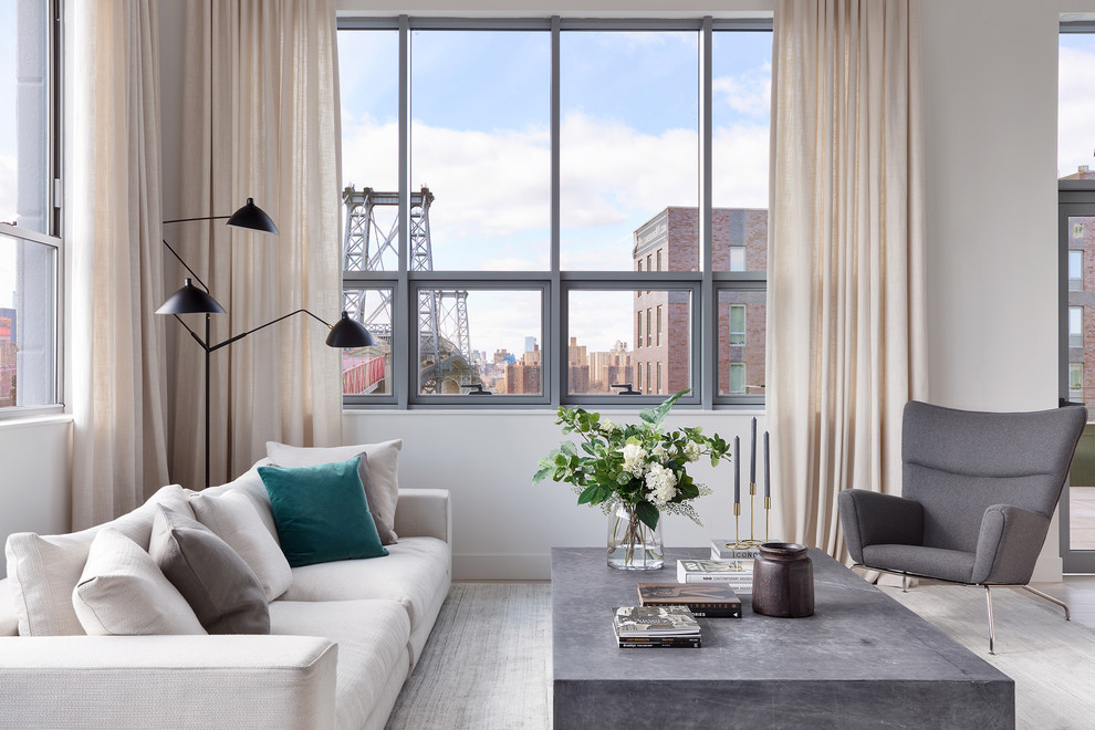 Living room - large contemporary loft-style light wood floor living room idea in New York with white walls and no fireplace