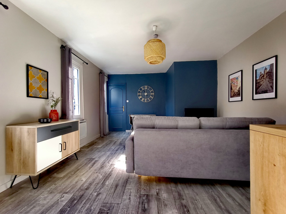 Ejemplo de sala de estar abierta escandinava pequeña sin chimenea con paredes azules, suelo vinílico, televisor independiente y suelo beige