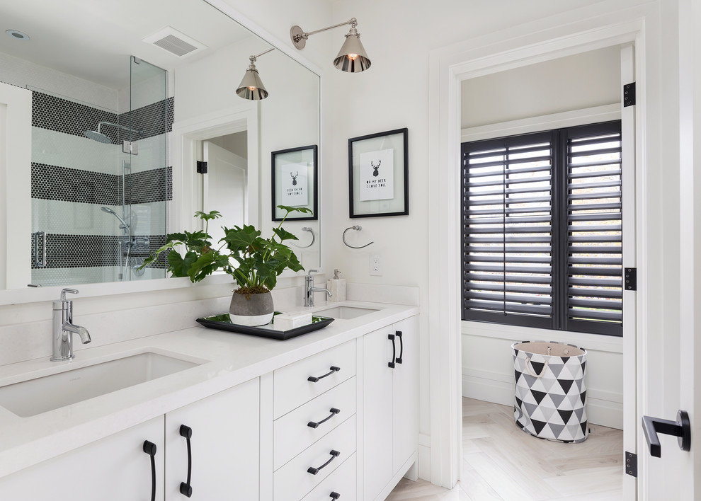 Photo of a transitional bathroom in Toronto with flat-panel cabinets, white cabinets, black and white tile, white walls, light hardwood floors, an undermount sink and beige floor.