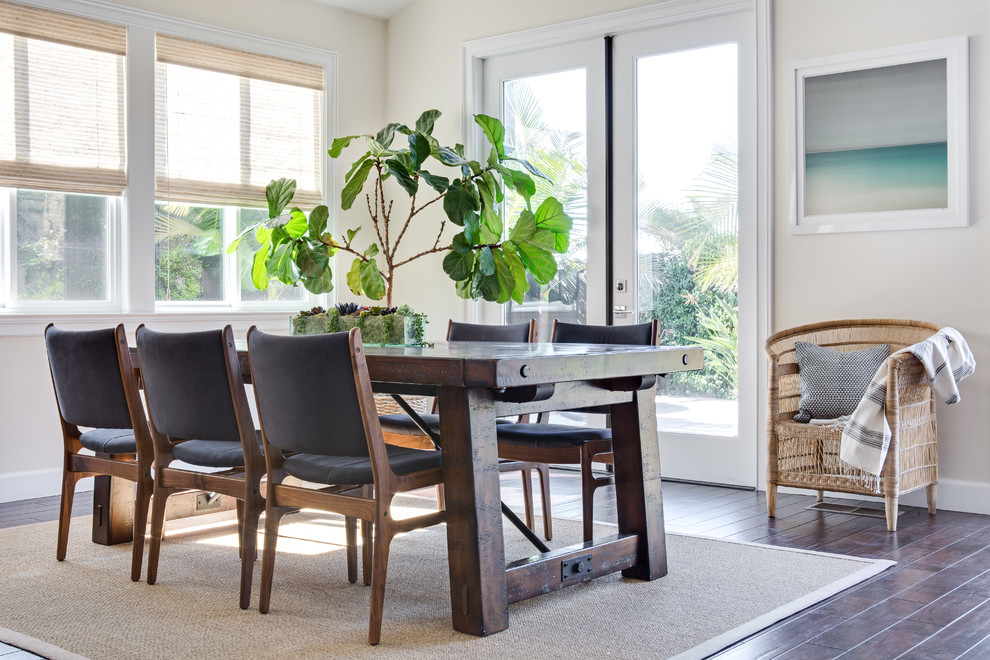 This is an example of a beach style dining room in San Diego with beige walls, dark hardwood floors and no fireplace.