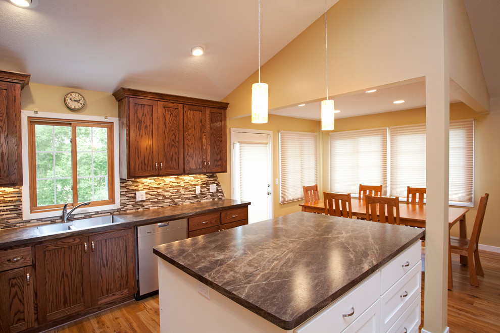 Eat-in kitchen - mid-sized transitional l-shaped medium tone wood floor eat-in kitchen idea in Milwaukee with dark wood cabinets, stainless steel appliances and an island
