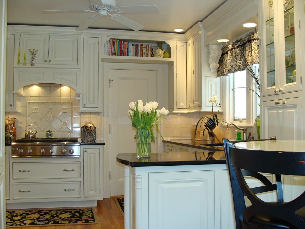 Example of a mid-sized u-shaped medium tone wood floor open concept kitchen design with a double-bowl sink, beaded inset cabinets, white cabinets, onyx countertops, white backsplash, ceramic backsplash, stainless steel appliances and a peninsula