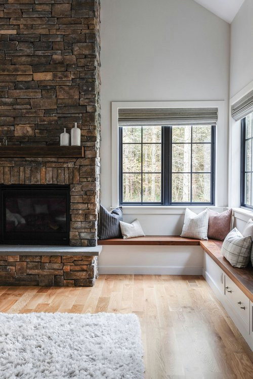 Inspiration for a mid-sized contemporary formal enclosed living room in Seattle with white walls, medium hardwood floors, a standard fireplace, a stone fireplace surround and a wall-mounted tv.