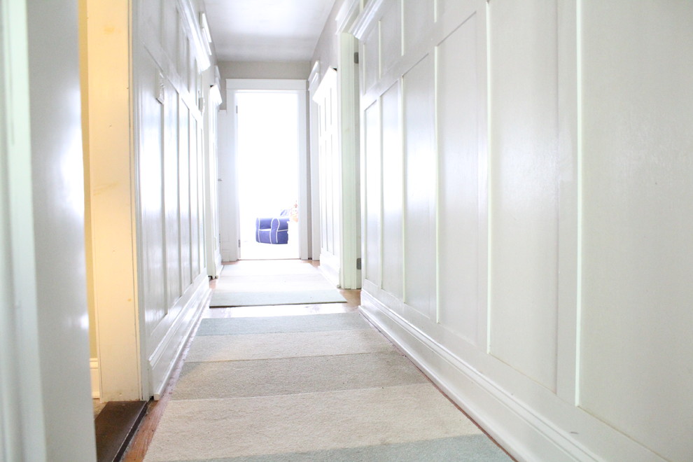 Inspiration for a mid-sized traditional hallway in New York with grey walls and light hardwood floors.