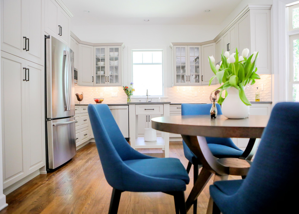 Example of a transitional kitchen design with raised-panel cabinets and an island