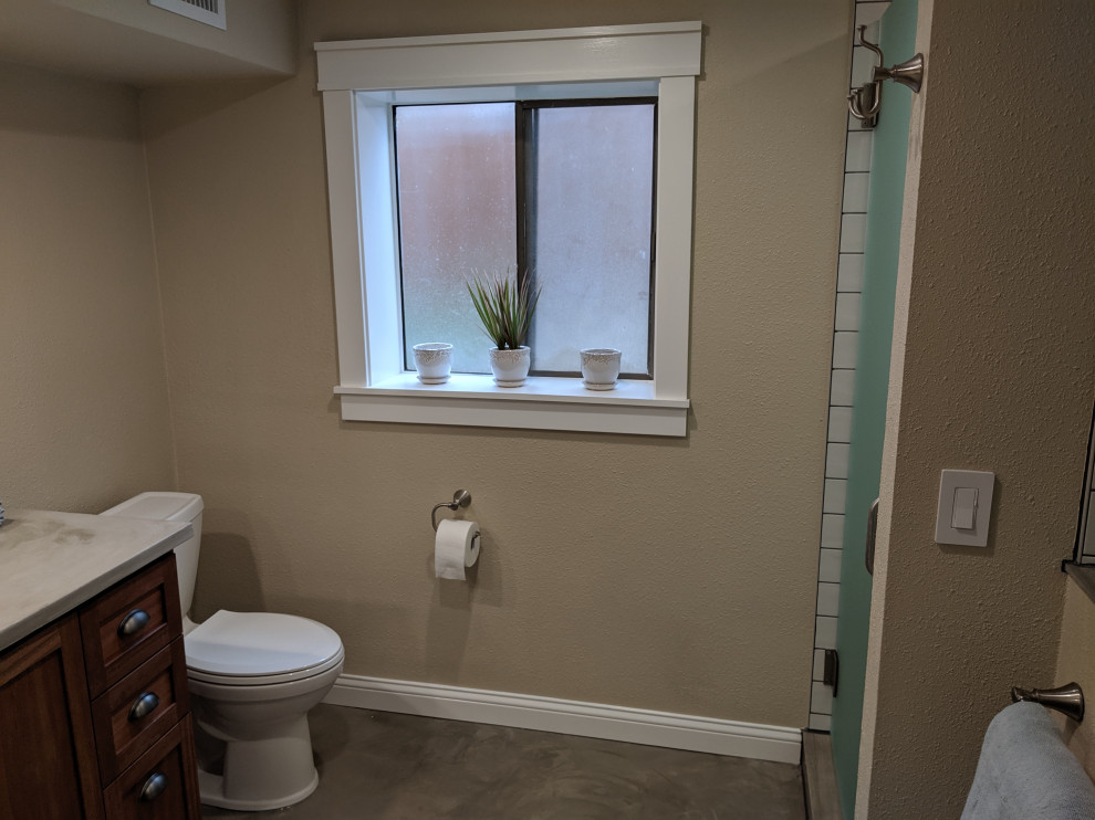 Photo of a small contemporary master bathroom in Portland with furniture-like cabinets, a two-piece toilet, beige walls, concrete floors, an undermount sink, concrete benchtops and a hinged shower door.