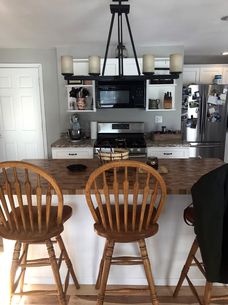 Inspiration for a mid-sized transitional eat-in kitchen remodel with a double-bowl sink, recessed-panel cabinets, white cabinets, laminate countertops, stainless steel appliances, an island and beige countertops