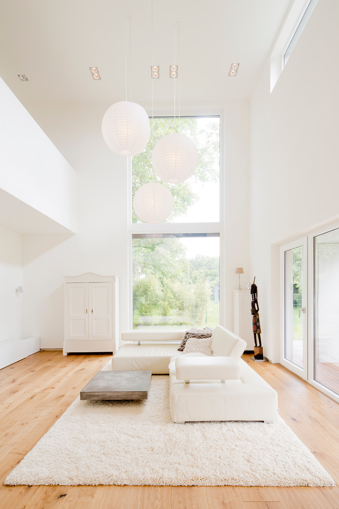 Wohnzimmer ohne Kamin With weißer Wandfarbe and hellem Holzboden in Cologne