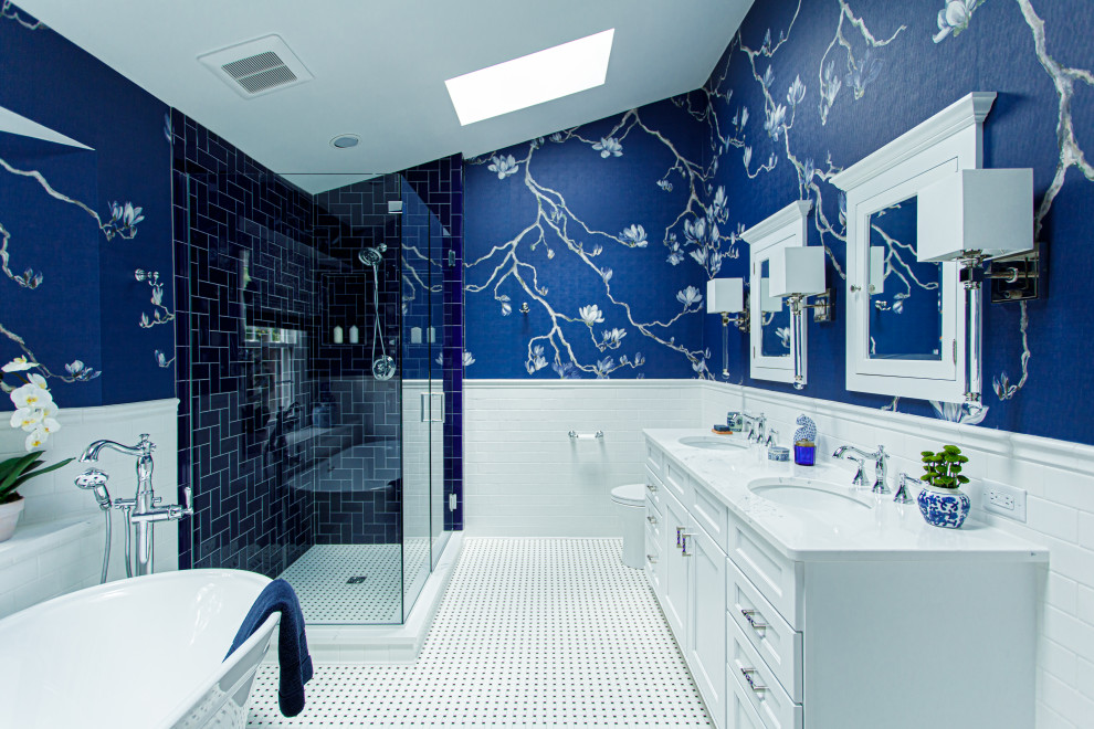 Photo of a mid-sized eclectic master bathroom in Cleveland with beaded inset cabinets, a freestanding tub, a corner shower, a two-piece toilet, white tile, porcelain tile, blue walls, porcelain floors, an undermount sink, engineered quartz benchtops, white floor, a hinged shower door, white benchtops, a niche, a double vanity, a freestanding vanity and wallpaper.