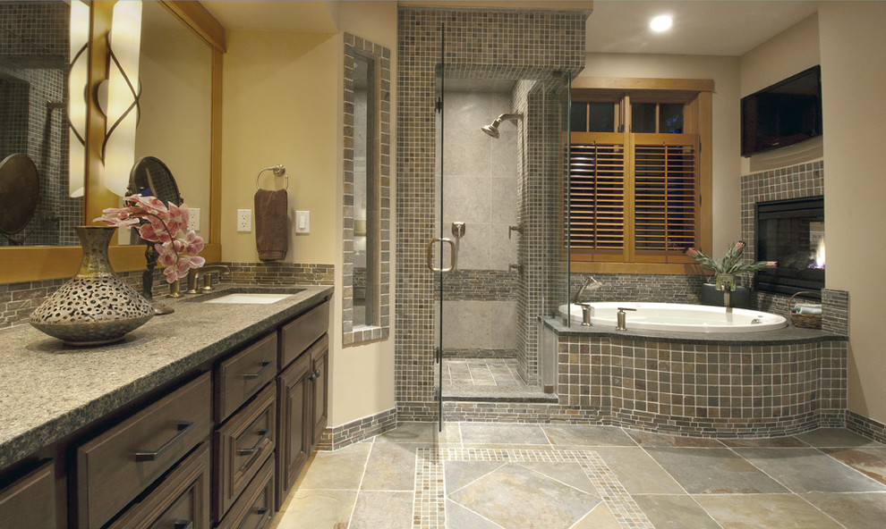 This is an example of a large contemporary master bathroom in Seattle with granite benchtops, raised-panel cabinets, dark wood cabinets, a drop-in tub, a corner shower, beige tile, brown tile, gray tile, multi-coloured tile, beige walls, an undermount sink and slate.