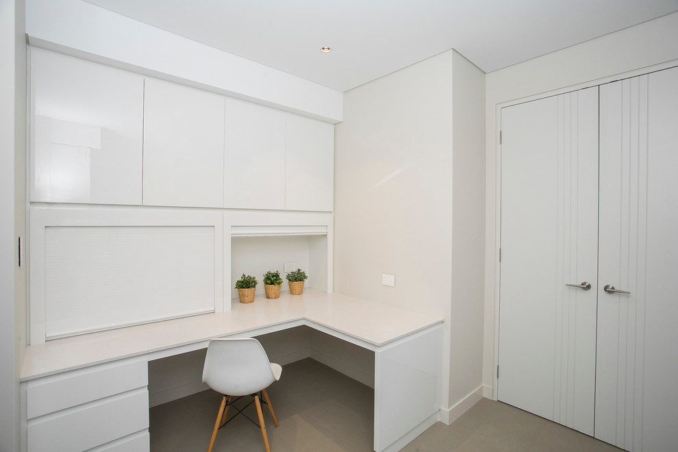 Photo of a tropical l-shaped laundry room in Perth with quartz benchtops.