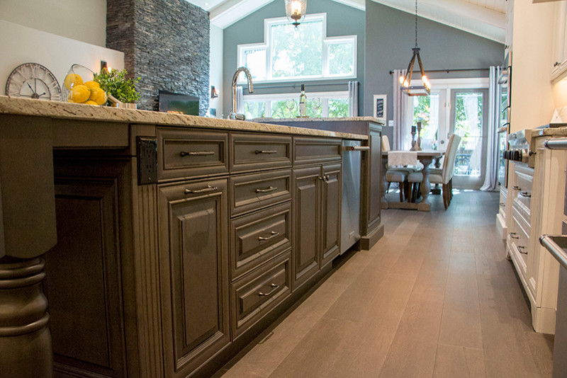 Eat-in kitchen - large transitional l-shaped eat-in kitchen idea with a double-bowl sink, shaker cabinets, white cabinets, beige backsplash, stainless steel appliances and an island
