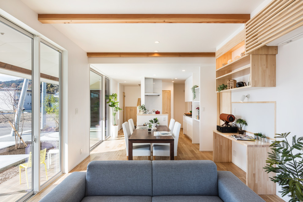 Scandinavian open plan dining with white walls, light hardwood floors and beige floor.