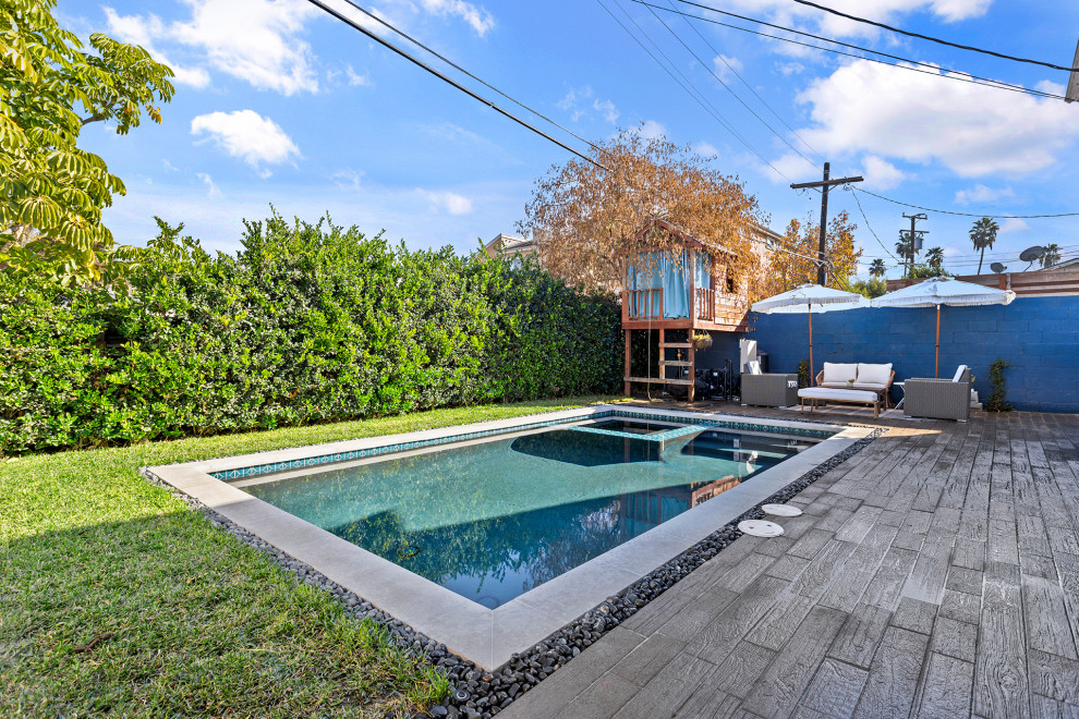 Foto di una piscina monocorsia minimalista rettangolare di medie dimensioni e dietro casa con una vasca idromassaggio e pavimentazioni in cemento