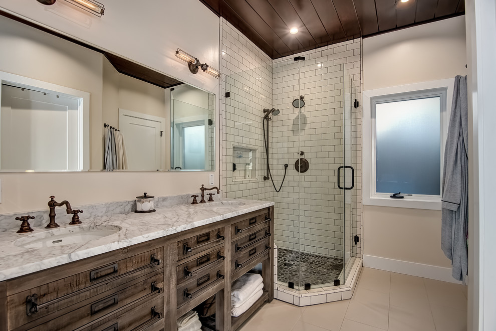 Country 3/4 bathroom in Orange County with flat-panel cabinets, medium wood cabinets, a corner shower, white tile, beige walls, an undermount sink, marble benchtops and a hinged shower door.