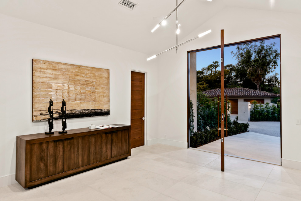 Design ideas for a contemporary foyer in San Diego with white walls, a pivot front door, a medium wood front door and white floors.
