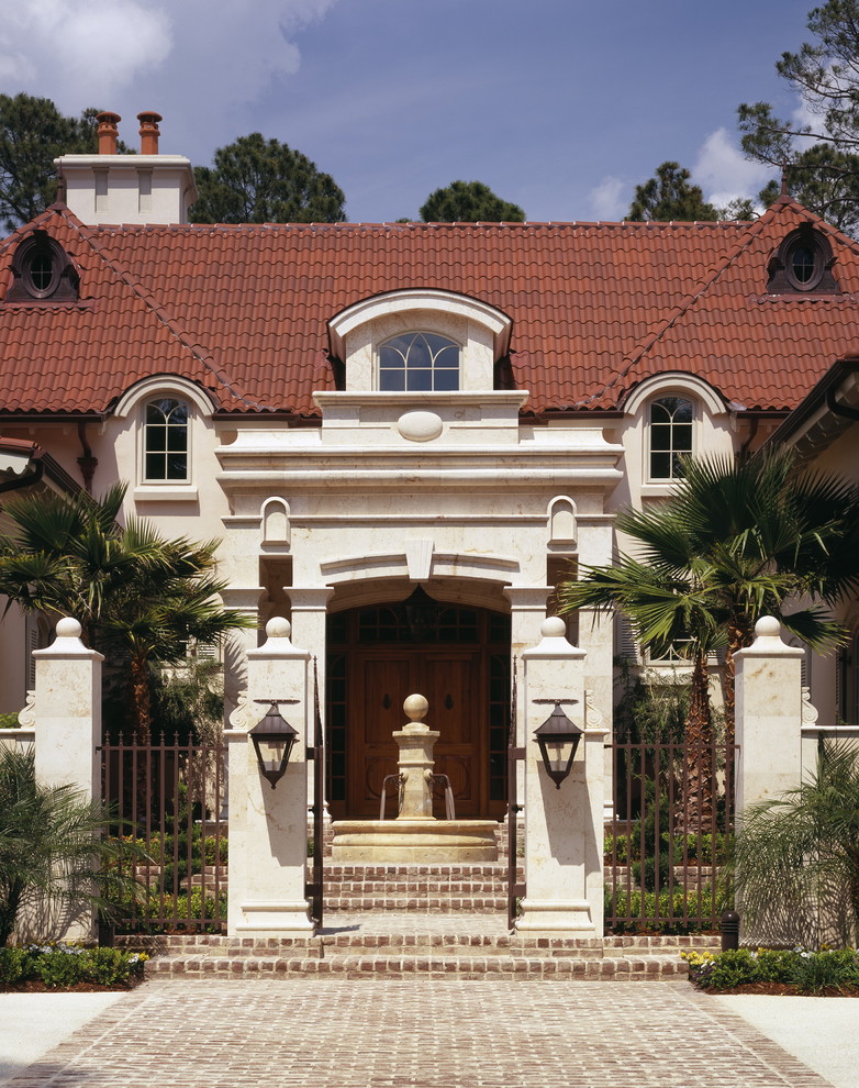 Large mediterranean two-storey stucco beige house exterior in Atlanta with a hip roof and a tile roof.