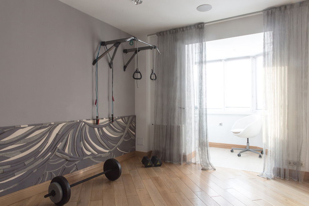 Photo of a mid-sized contemporary home weight room in Moscow with grey walls, medium hardwood floors and brown floor.