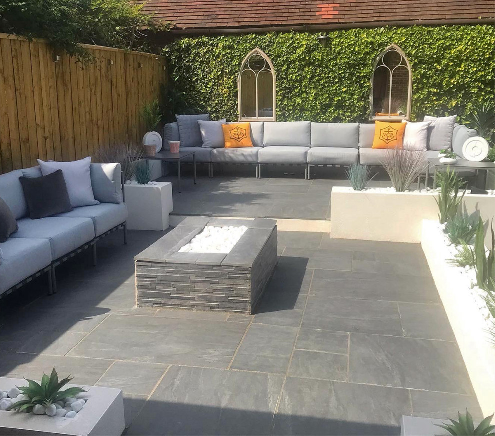 This is an example of a medium sized contemporary back patio in Essex with tiled flooring.