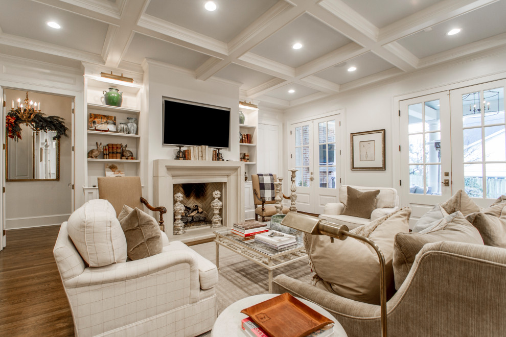 Photo of a large traditional open concept family room in Little Rock with white walls, medium hardwood floors, a standard fireplace, a plaster fireplace surround, a wall-mounted tv and brown floor.
