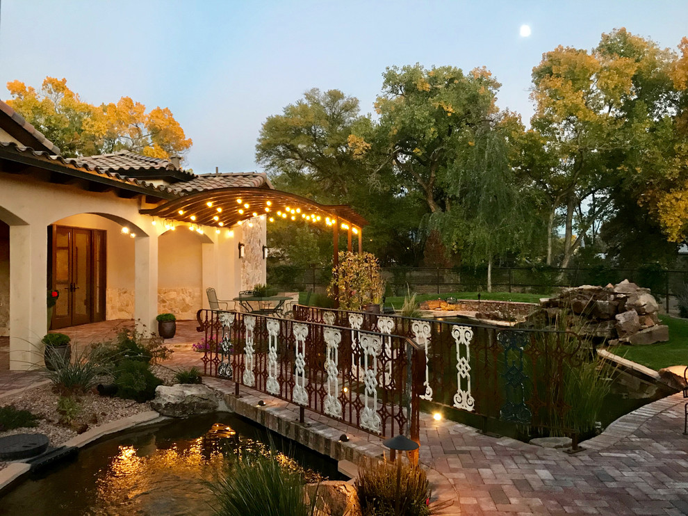 This is an example of a country front yard verandah in Albuquerque with a water feature and brick pavers.