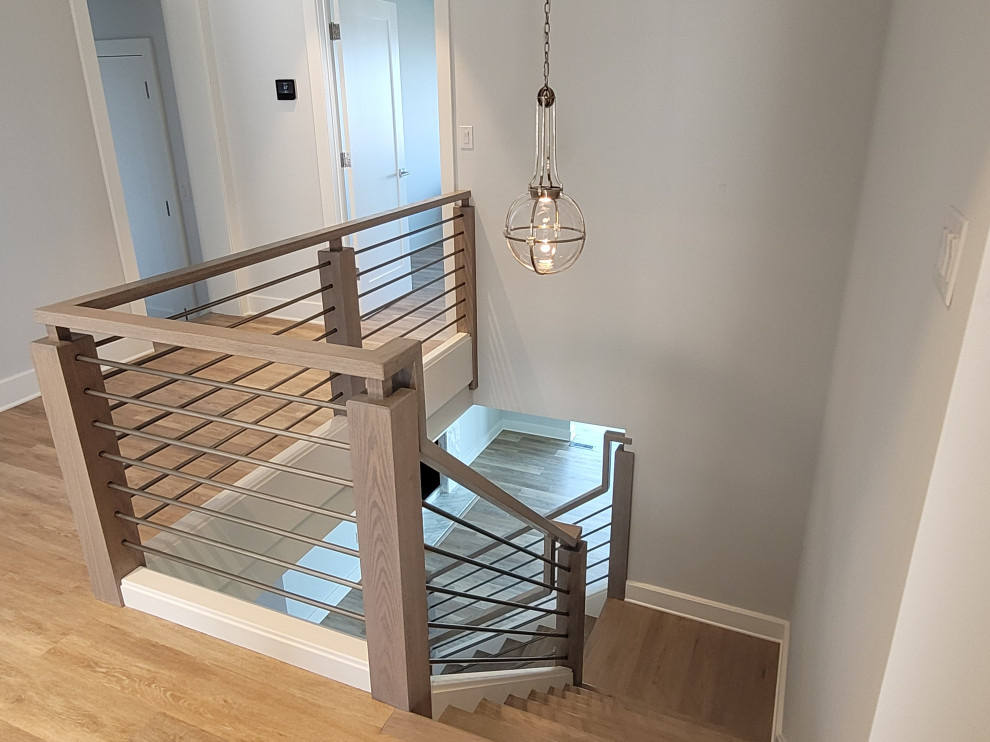 ボルチモアにある高級な小さなコンテンポラリースタイルのおしゃれなかね折れ階段 (木の蹴込み板、金属の手すり) の写真