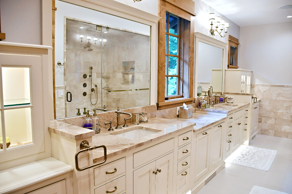 This is an example of a mid-sized traditional master bathroom in Boston with recessed-panel cabinets, white cabinets, beige tile, white walls, marble floors, an undermount sink, white floor and beige benchtops.