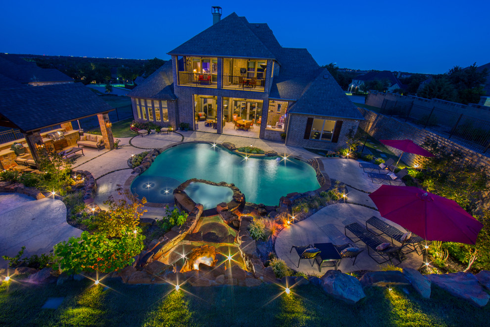 Mid-sized country backyard custom-shaped natural pool in Dallas with a hot tub.