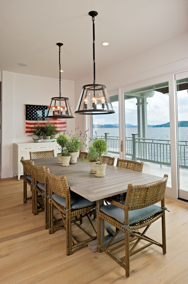 This is an example of a beach style dining room in Seattle with white walls and medium hardwood floors.