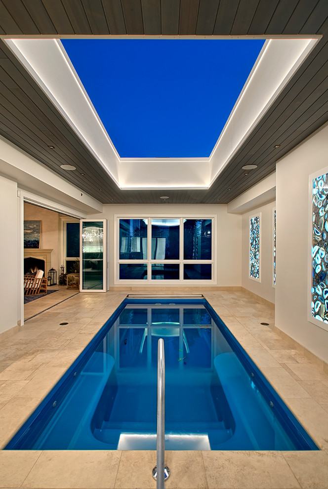 This is an example of a mid-sized transitional indoor rectangular lap pool in Chicago with a pool house and tile.