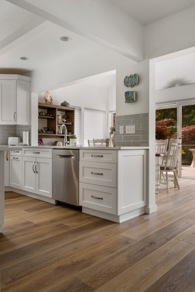 Medium sized beach style galley kitchen/diner in Seattle with a built-in sink, beaded cabinets, white cabinets, marble worktops, grey splashback, ceramic splashback, stainless steel appliances, vinyl flooring, multiple islands, brown floors, white worktops and a coffered ceiling.