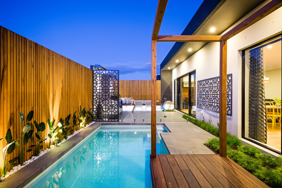 This is an example of a small contemporary backyard custom-shaped lap pool in Melbourne with decking.