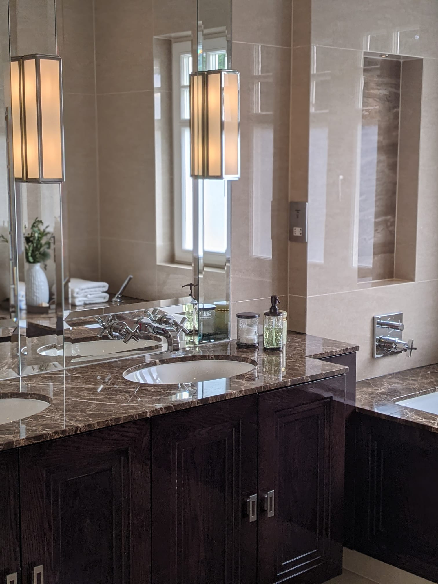 Emprador marble tops with dark oak stained triple step His and Hers floating vanity unit and dark stained high gloss bath panel