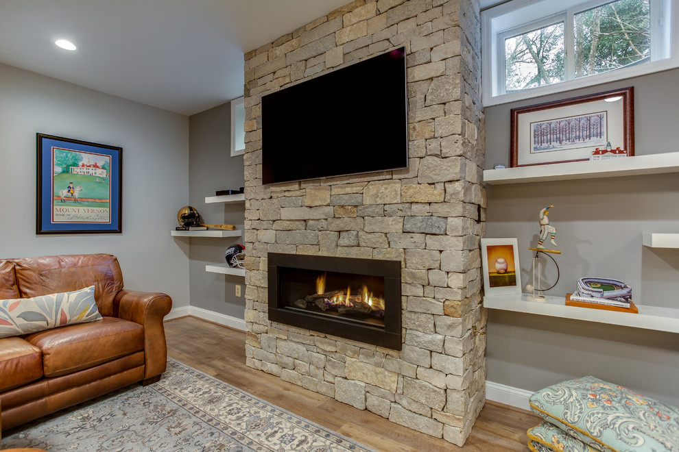 Design ideas for an expansive arts and crafts walk-out basement in DC Metro with vinyl floors, a standard fireplace and a stone fireplace surround.