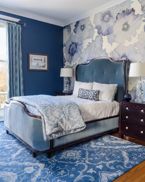 bedroom with blue painted wall and blue and white flowered wallpaper